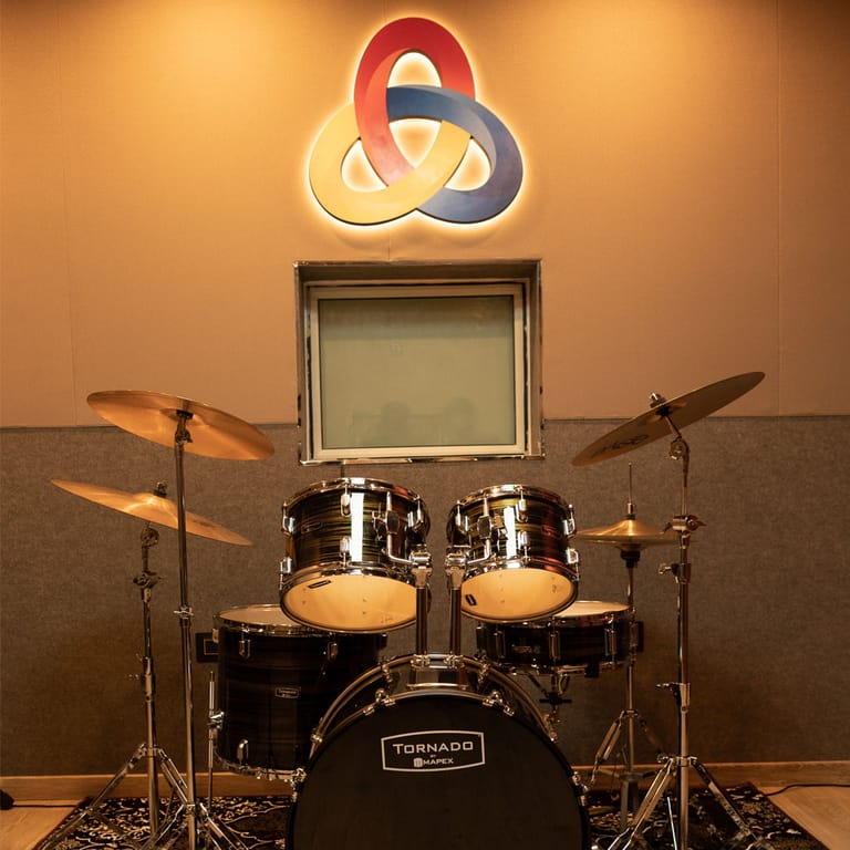 The Infinity Learning Space logo above the drum kit